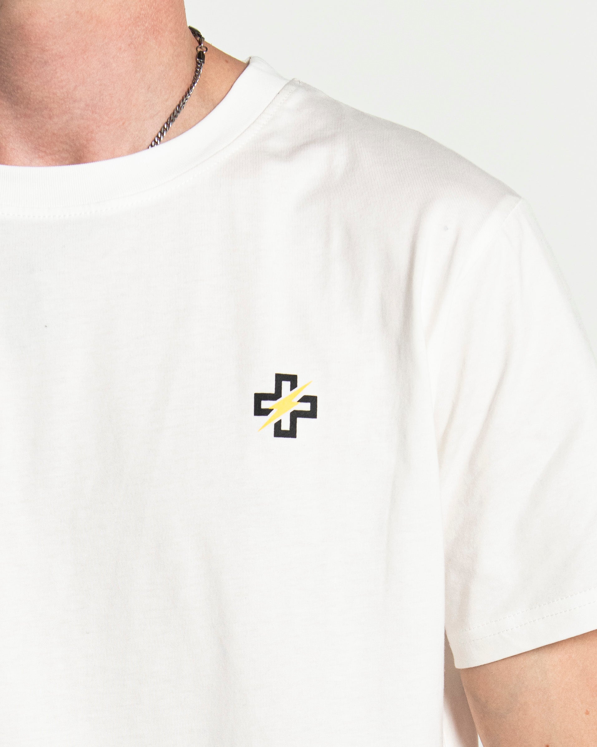 Close-up of PSTVNRG icon on white T-Shirt
