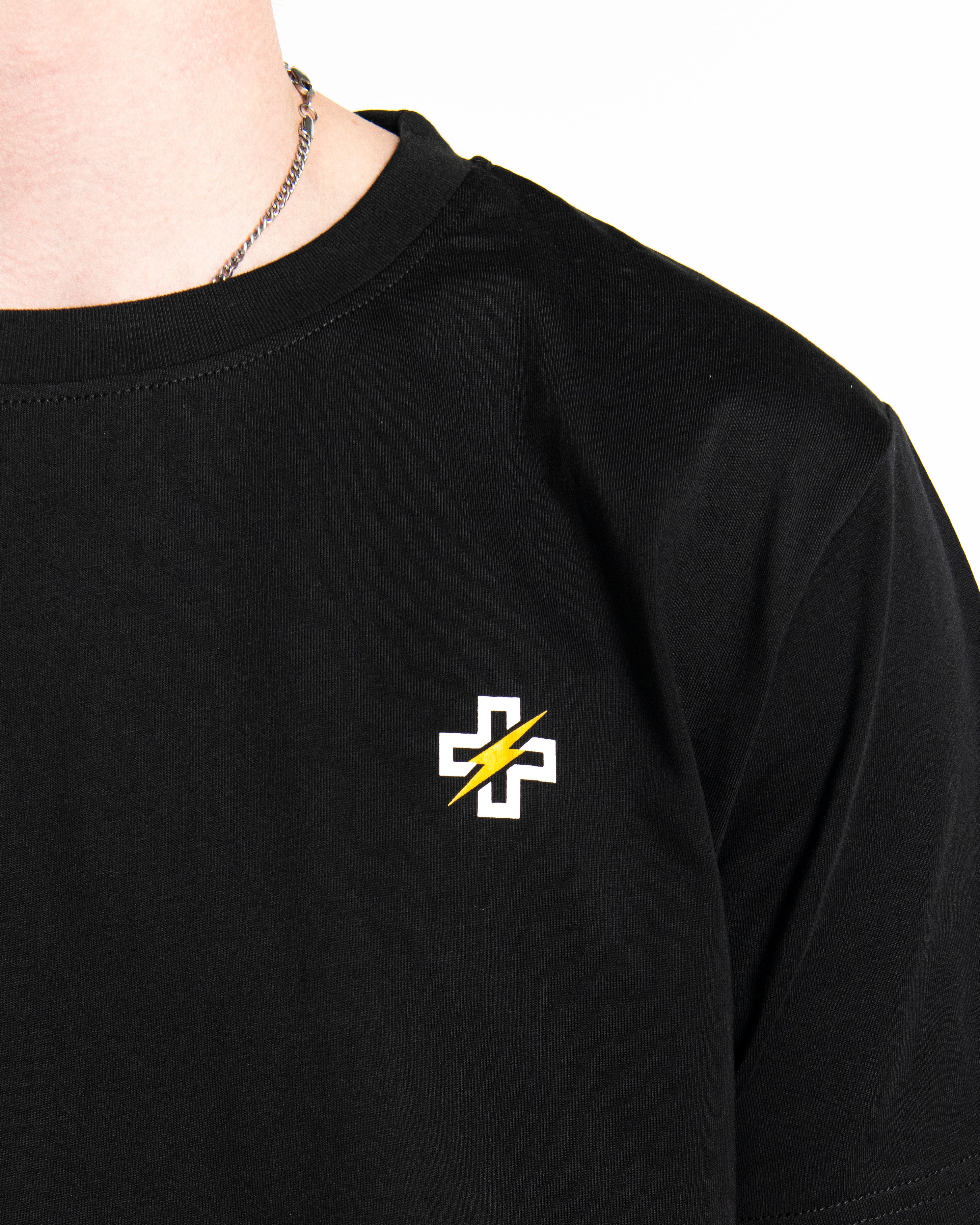 Close-up of PSTVNRG icon on black T-Shirt